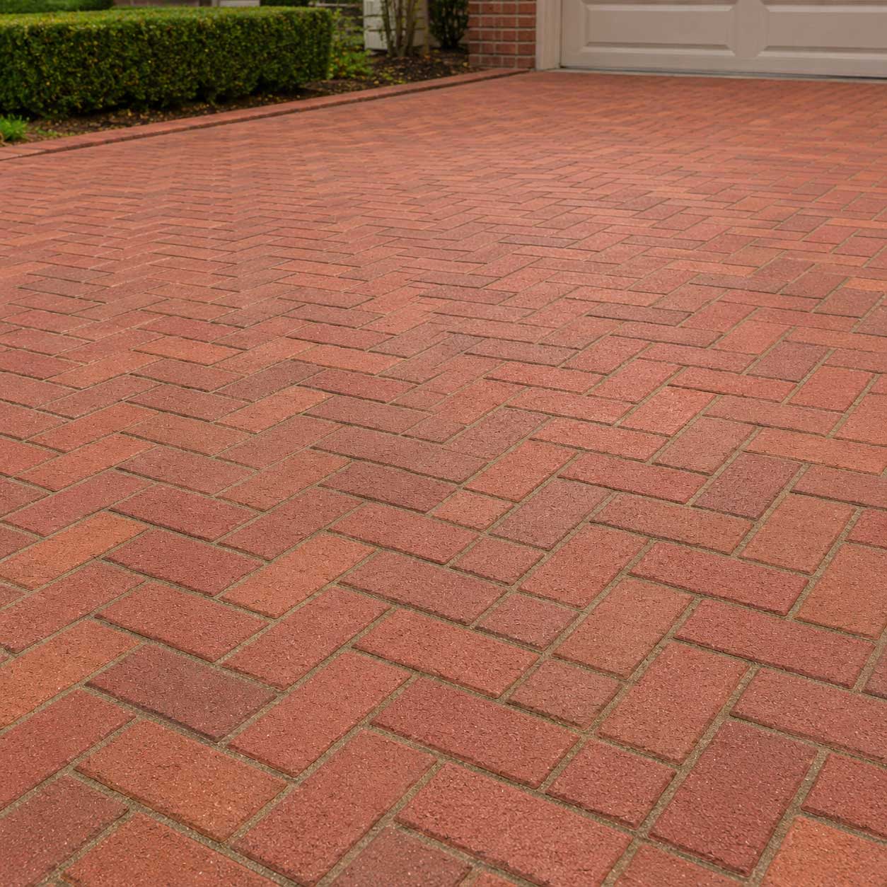 Red brick driveway with herringbone pattern layout in Fond du Lac, Wisconsin, showing professional driveway cleaning and exterior maintenance services