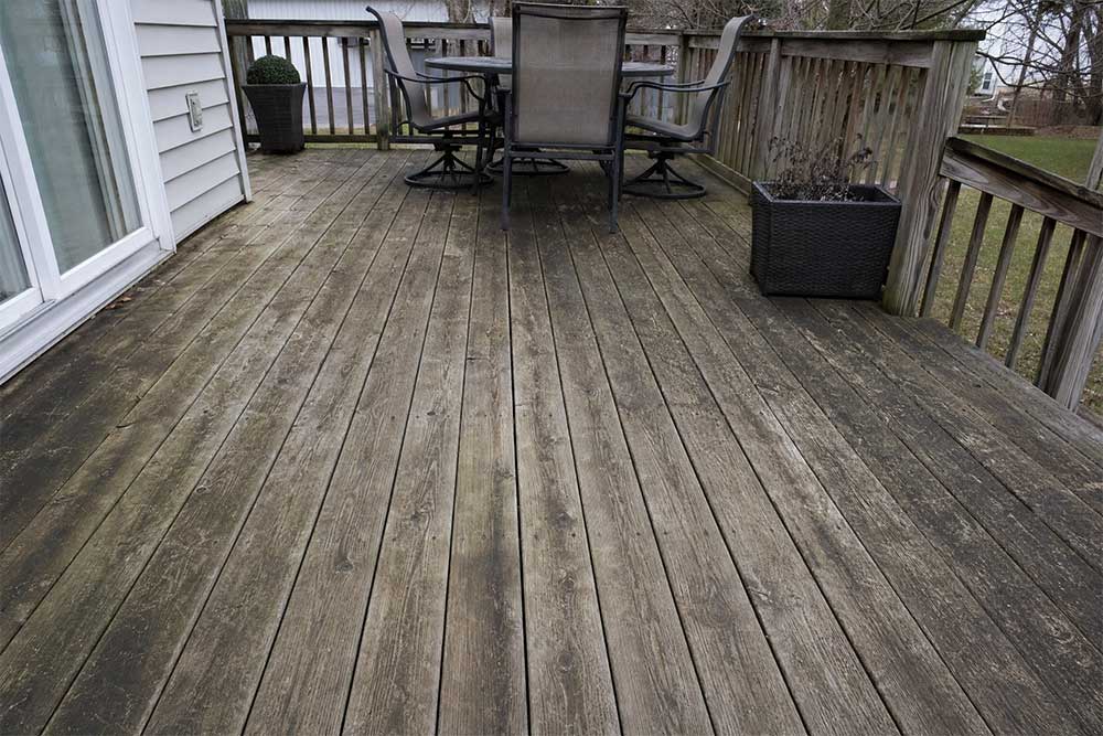 Weathered wooden deck with dirt and mold buildup before professional deck cleaning in Fond du Lac, Wisconsin