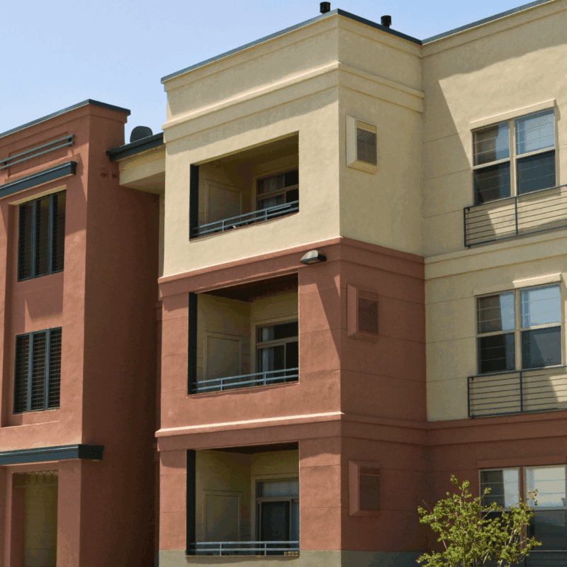 Modern multi-unit residential building in Fond du Lac, Wisconsin featuring red brick and cream-colored exterior facades with metal railings and large windows, ideal for apartment complex and HOA exterior cleaning services