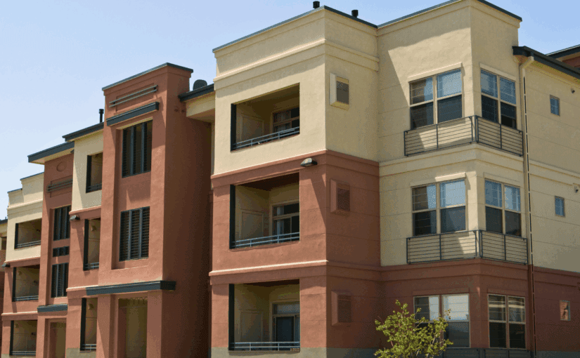 Modern multi-unit residential building in Fond du Lac, Wisconsin featuring red brick and cream-colored exterior facades with metal railings and large windows, ideal for apartment complex and HOA exterior cleaning services